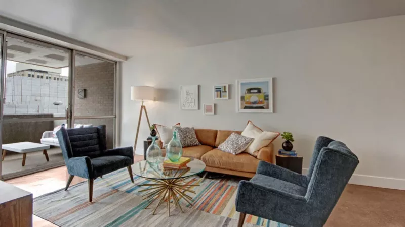 A bright and airy living space with floor-to-ceiling windows leading to a private balcony.