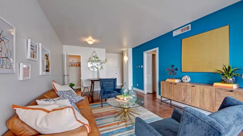 A modern apartment living room with a mix of comfortable seating and artistic touches.